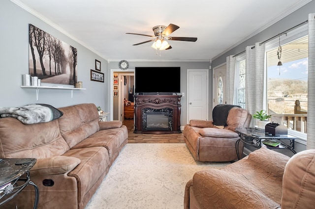 living area featuring ceiling fan, ornamental molding, wood finished floors, and a glass covered fireplace