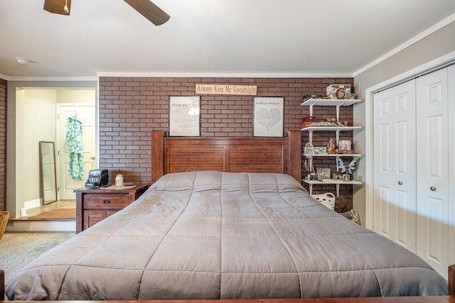 bedroom featuring a ceiling fan, brick wall, ornamental molding, and a closet