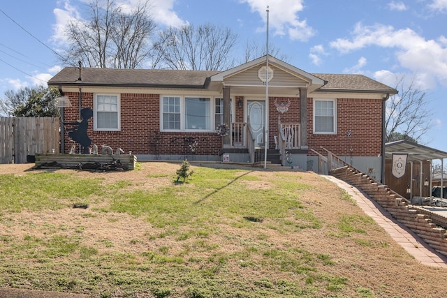 view of front of home featuring brick siding, a front lawn, and fence