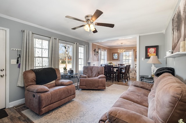 living room featuring ceiling fan, crown molding, baseboards, and wood finished floors