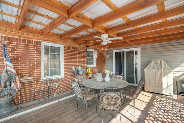 wooden terrace with a ceiling fan and outdoor dining space