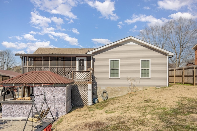 back of house featuring a sunroom and fence