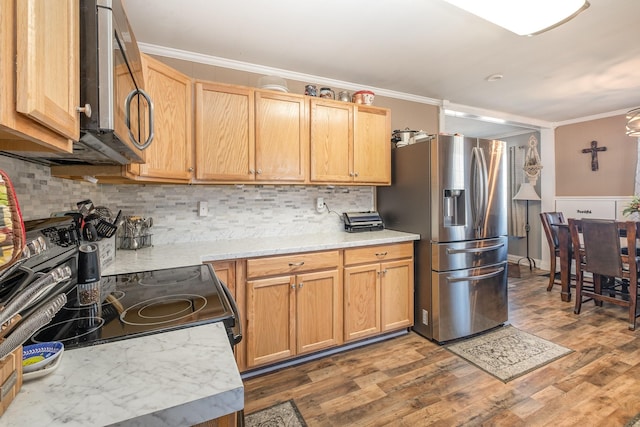 kitchen with decorative backsplash, ornamental molding, stainless steel appliances, and wood finished floors