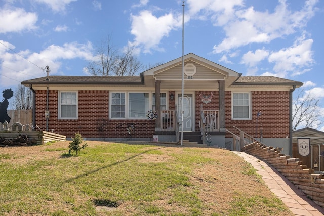 view of front of home with a front yard, fence, and brick siding