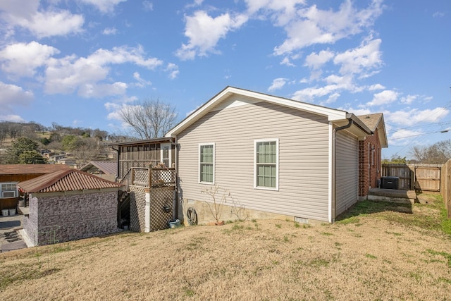 view of property exterior with fence and a lawn