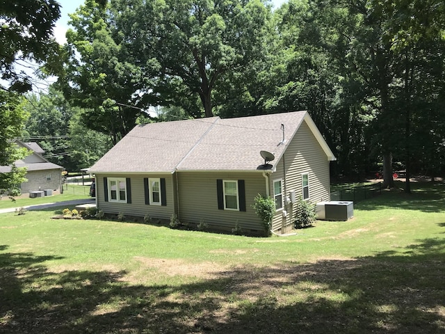 view of front of home with crawl space, roof with shingles, and a front yard