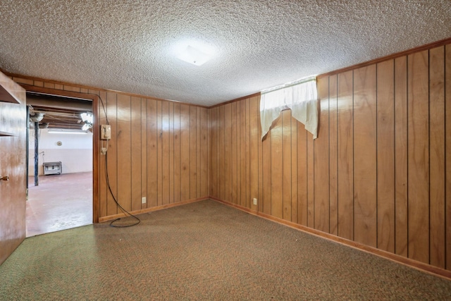 carpeted empty room featuring a textured ceiling and wooden walls