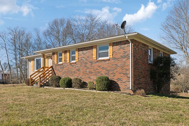 ranch-style house with a front yard and brick siding