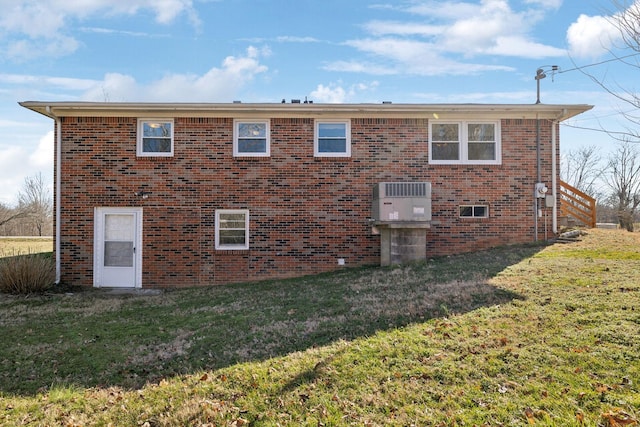 back of house featuring brick siding and a yard