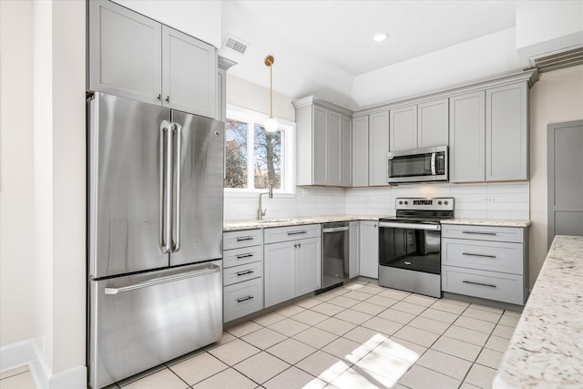 kitchen with pendant lighting, visible vents, decorative backsplash, gray cabinetry, and appliances with stainless steel finishes