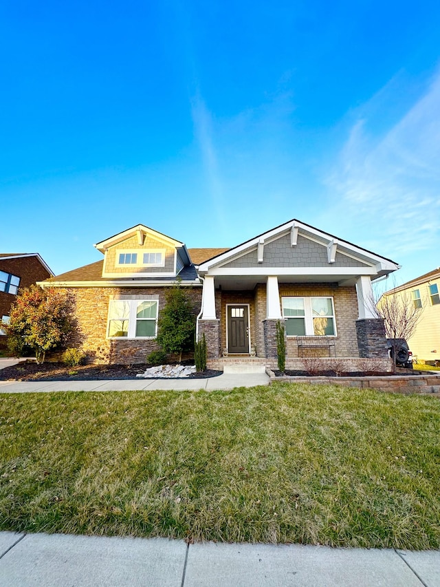 view of front of home featuring stone siding and a front lawn