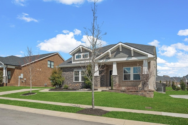 craftsman house featuring brick siding and a front lawn