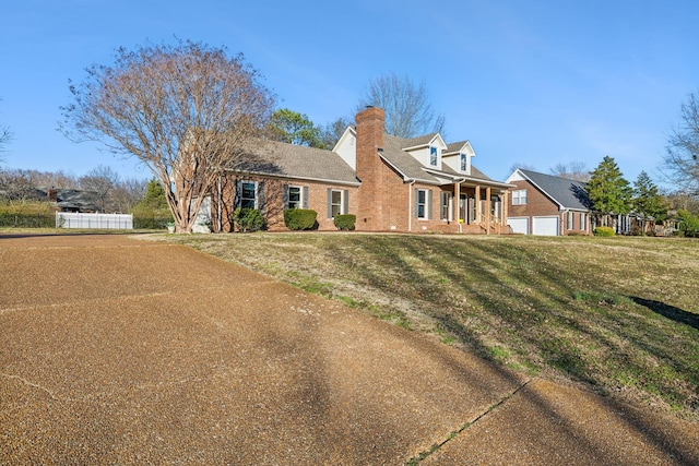 cape cod house with a garage, a front lawn, a chimney, and fence