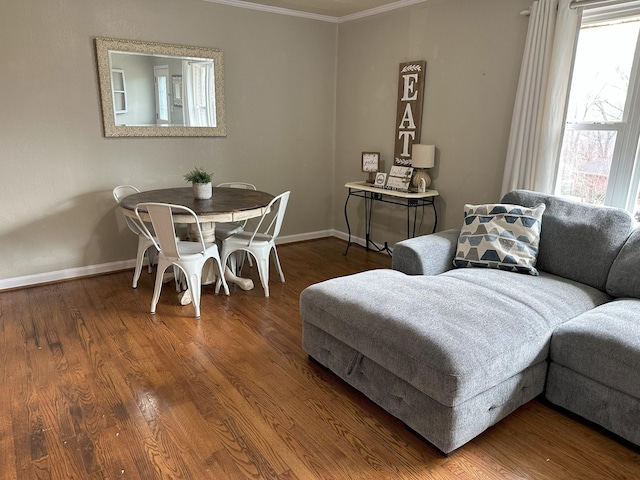 interior space with baseboards, plenty of natural light, ornamental molding, and wood finished floors