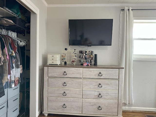 interior space featuring ornamental molding, wood finished floors, and baseboards