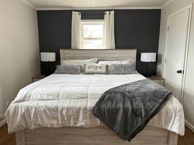 bedroom featuring ornamental molding, wood finished floors, and baseboards