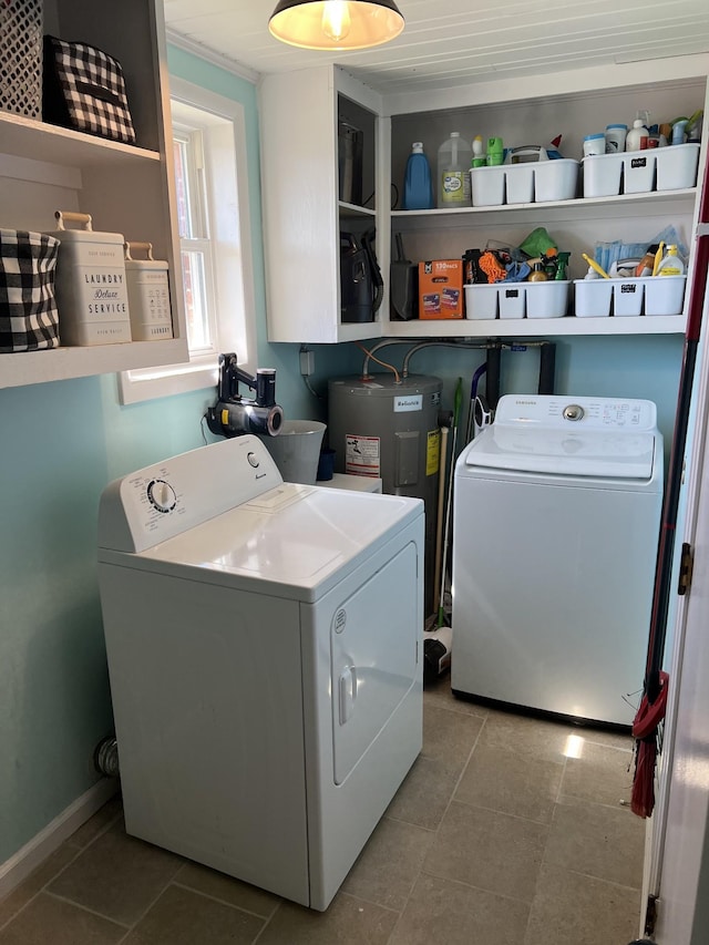 laundry area featuring laundry area, electric water heater, washing machine and clothes dryer, and tile patterned floors