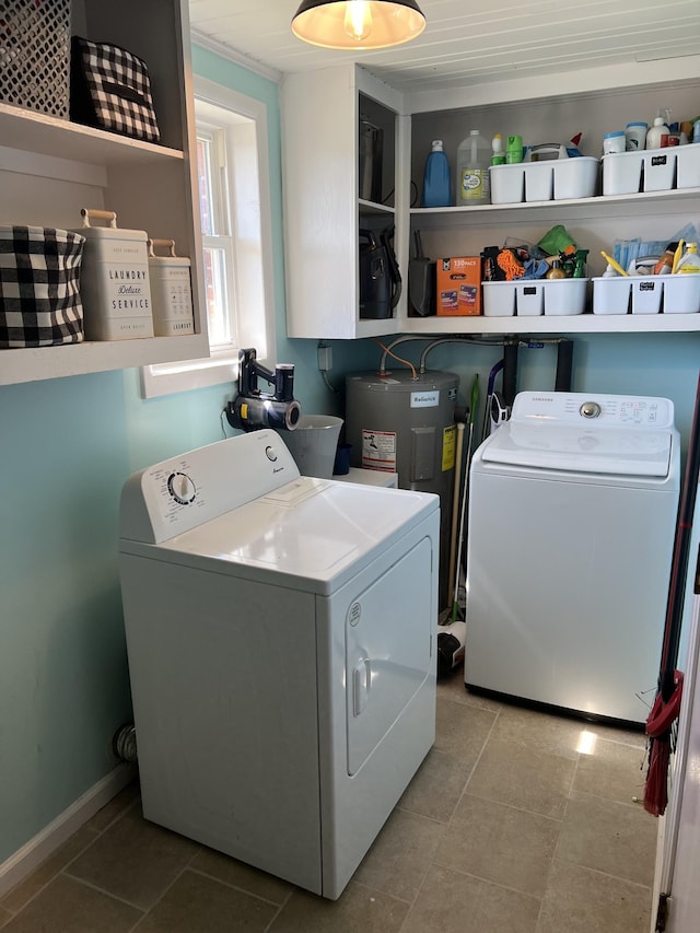 washroom with laundry area, electric water heater, washing machine and clothes dryer, and tile patterned floors