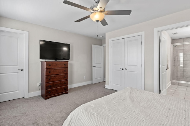 carpeted bedroom with a ceiling fan, ensuite bath, baseboards, and a closet