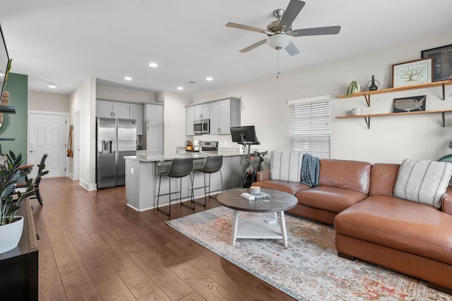 living room with recessed lighting, dark wood-style flooring, ceiling fan, and baseboards