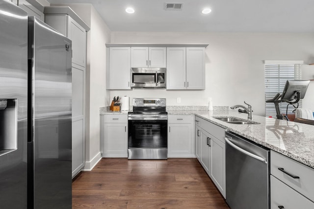 kitchen with visible vents, light stone counters, appliances with stainless steel finishes, dark wood-type flooring, and a sink