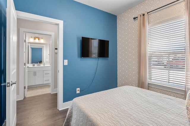 bedroom with a sink, baseboards, and wood finished floors