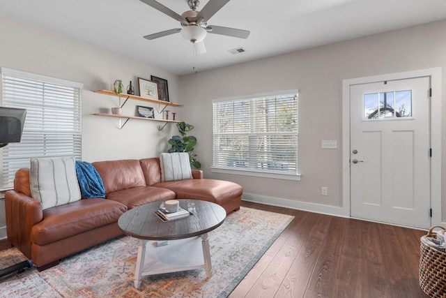 living room with a ceiling fan, baseboards, visible vents, and wood finished floors