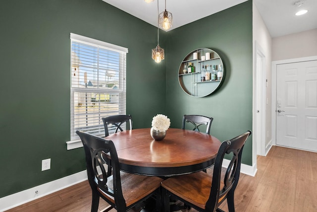 dining area with light wood-type flooring and baseboards