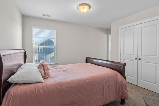 carpeted bedroom featuring visible vents and a closet