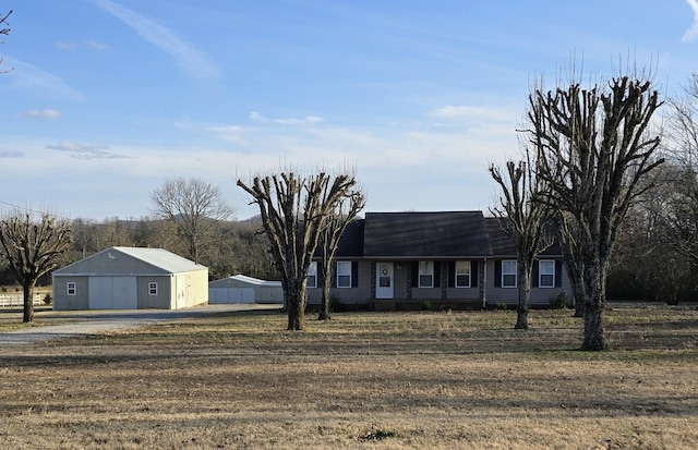 view of front facade with an outbuilding, a pole building, and roof with shingles