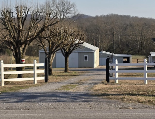 view of street with a rural view and driveway