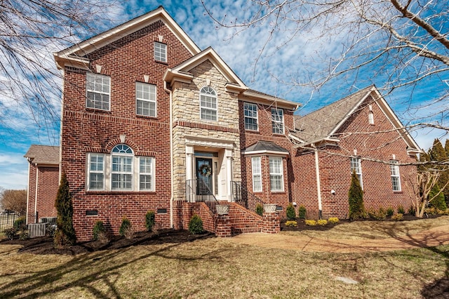 traditional-style house featuring stone siding, brick siding, crawl space, and a front yard