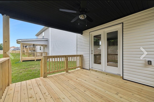 wooden deck featuring a yard and a ceiling fan