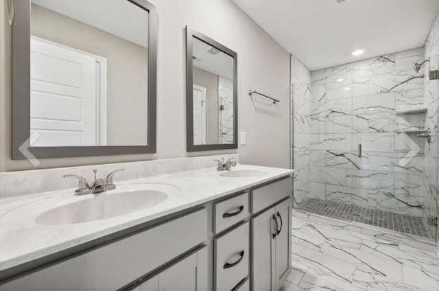 full bath featuring a marble finish shower, marble finish floor, double vanity, and a sink