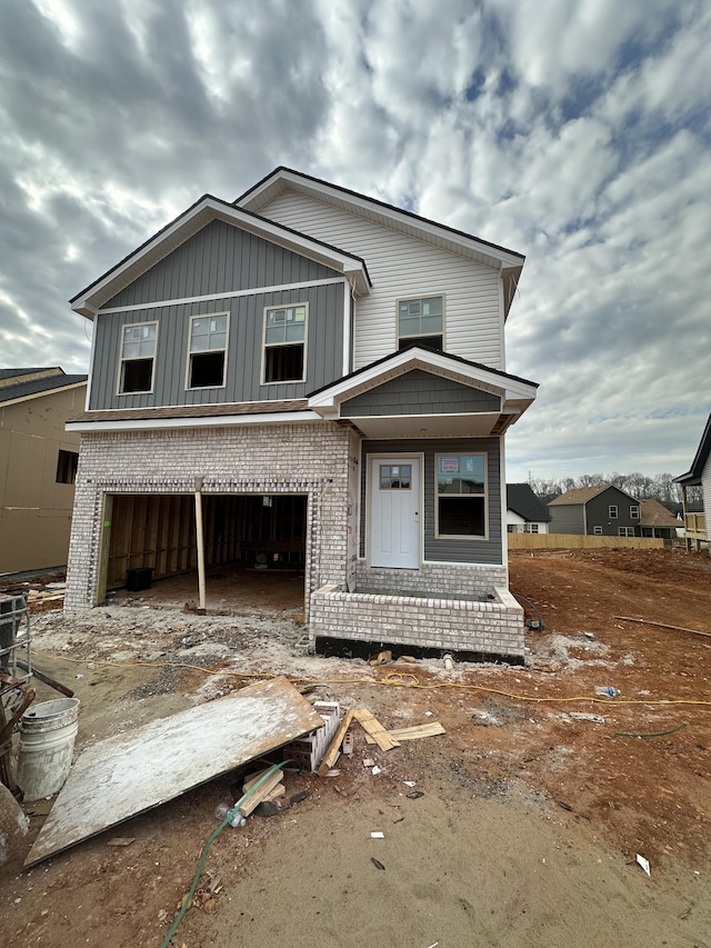 view of front of house with brick siding, board and batten siding, and an attached garage