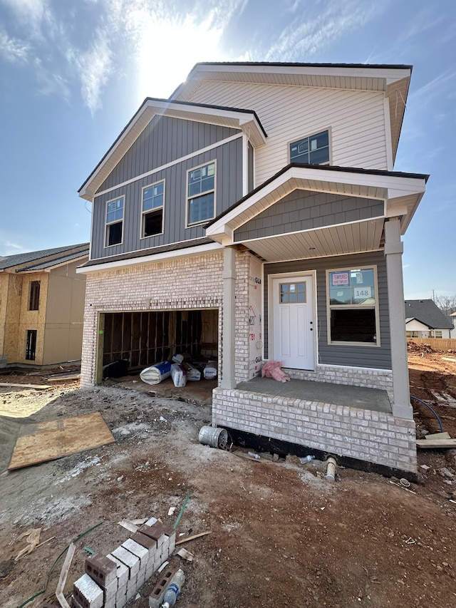 view of front of home with a garage, covered porch, and board and batten siding