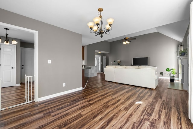 living area featuring lofted ceiling, dark wood-style floors, baseboards, and ceiling fan with notable chandelier