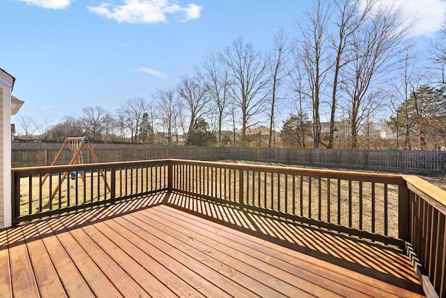 wooden terrace featuring a fenced backyard and a playground