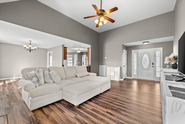 living area featuring visible vents, baseboards, dark wood-type flooring, and ceiling fan with notable chandelier