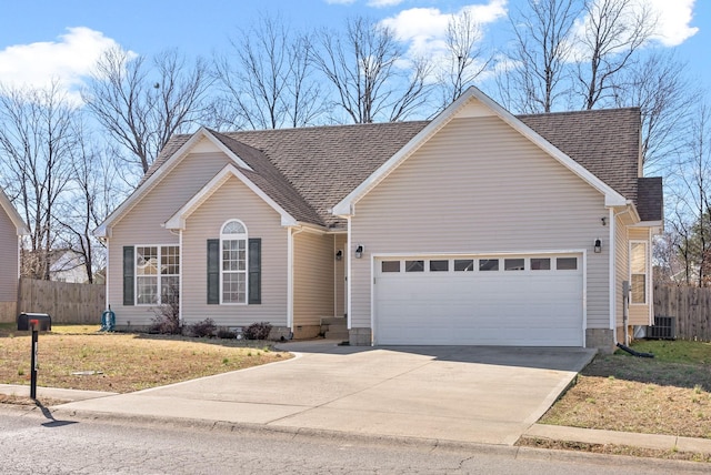 ranch-style house featuring a shingled roof, concrete driveway, fence, and an attached garage