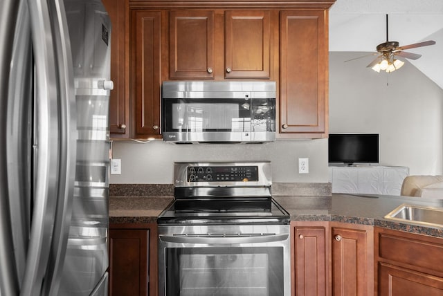 kitchen with brown cabinets, ceiling fan, stainless steel appliances, and a sink