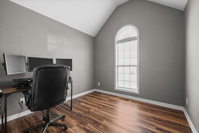 office space featuring lofted ceiling, visible vents, baseboards, and wood finished floors