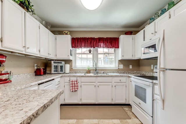 kitchen with white appliances, white cabinetry, and a sink