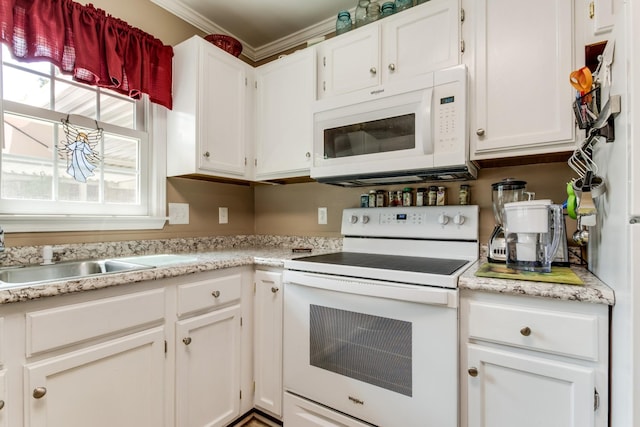 kitchen with white appliances, light countertops, and white cabinetry