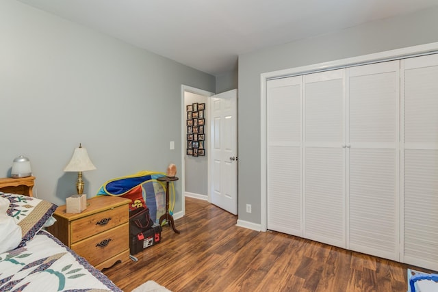 bedroom with a closet, baseboards, and wood finished floors