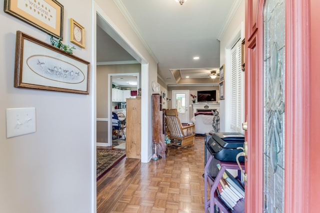 entrance foyer with ornamental molding, a fireplace, and a ceiling fan