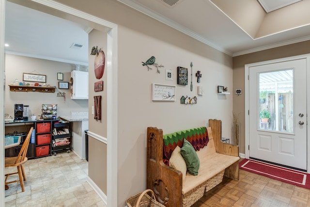 foyer with visible vents, crown molding, and baseboards