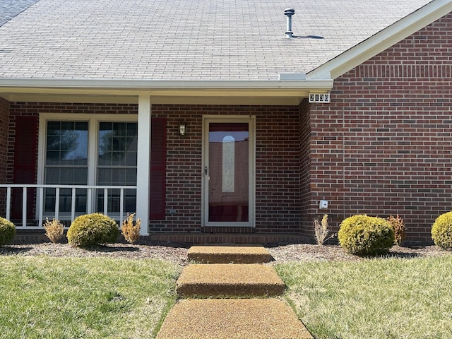 view of exterior entry featuring brick siding