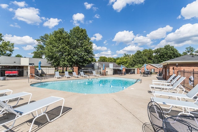 community pool featuring fence and a patio