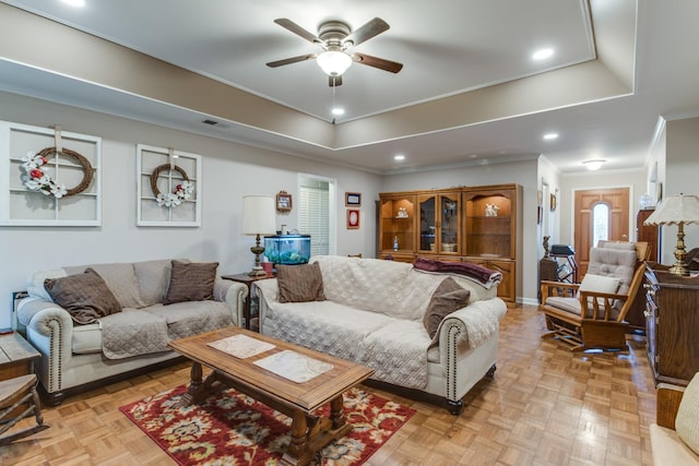 living room with crown molding, ceiling fan, a tray ceiling, and recessed lighting